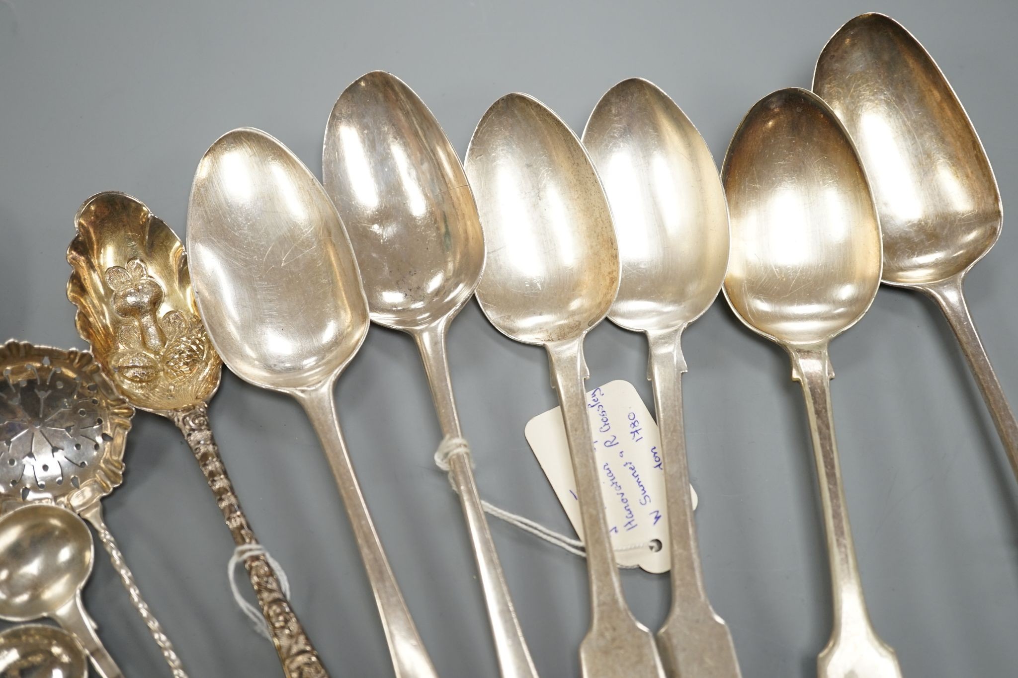 A small collection of 18th century and later silver flatware, including a table spoon by Thomas Eustace, Exeter, 1785, two 18th century silver lace back dessert spoons, an 18th century 'berry' spoon, a George III silver